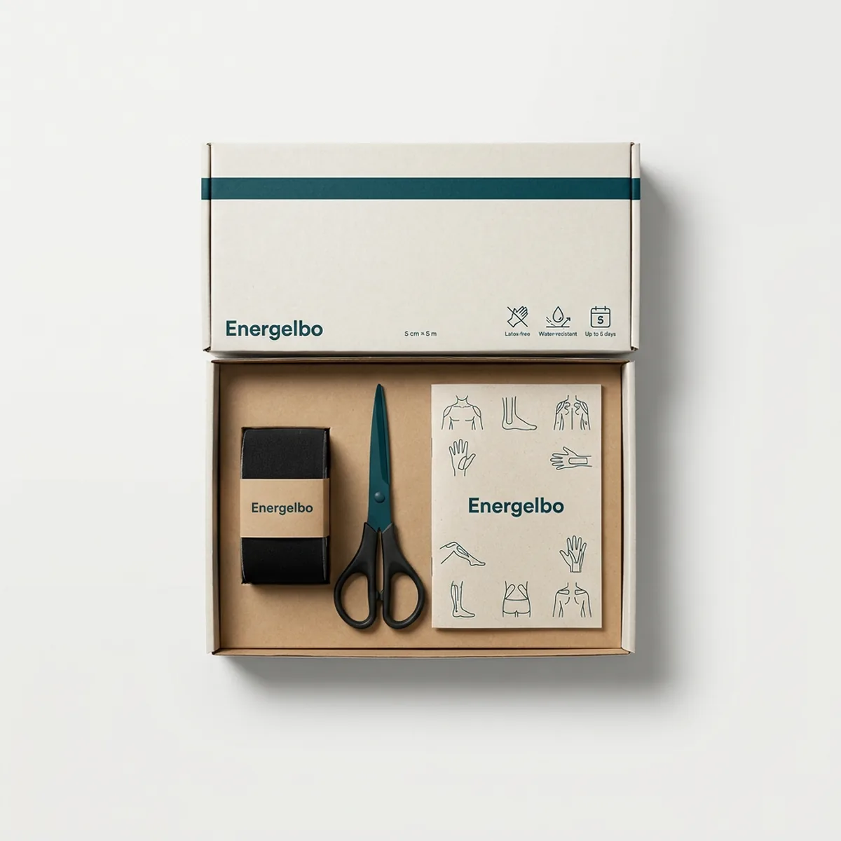 Energelbo Starter Kit laid out in an open kraft-white box: one black tape roll, tape scissors and an A5 printed application guide
