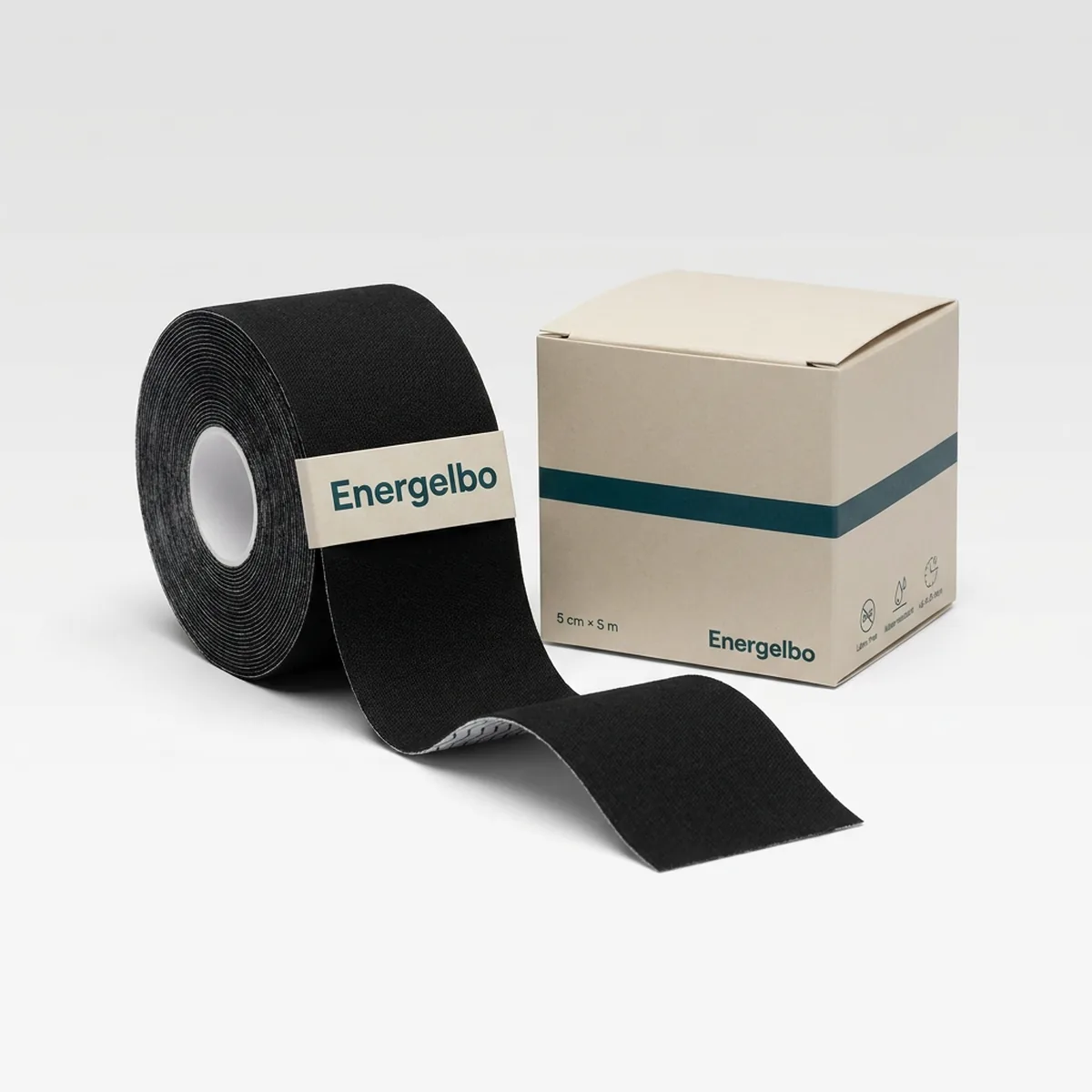 Single roll of black Energelbo kinesiology tape, 5 cm wide, standing upright with a length of tape unrolled towards the camera